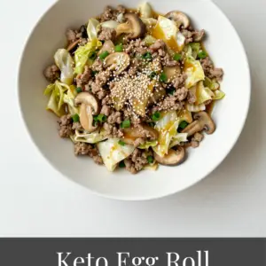 Keto egg roll in a bowl stir-fry with ground pork, cabbage, and Asian seasonings in a skillet