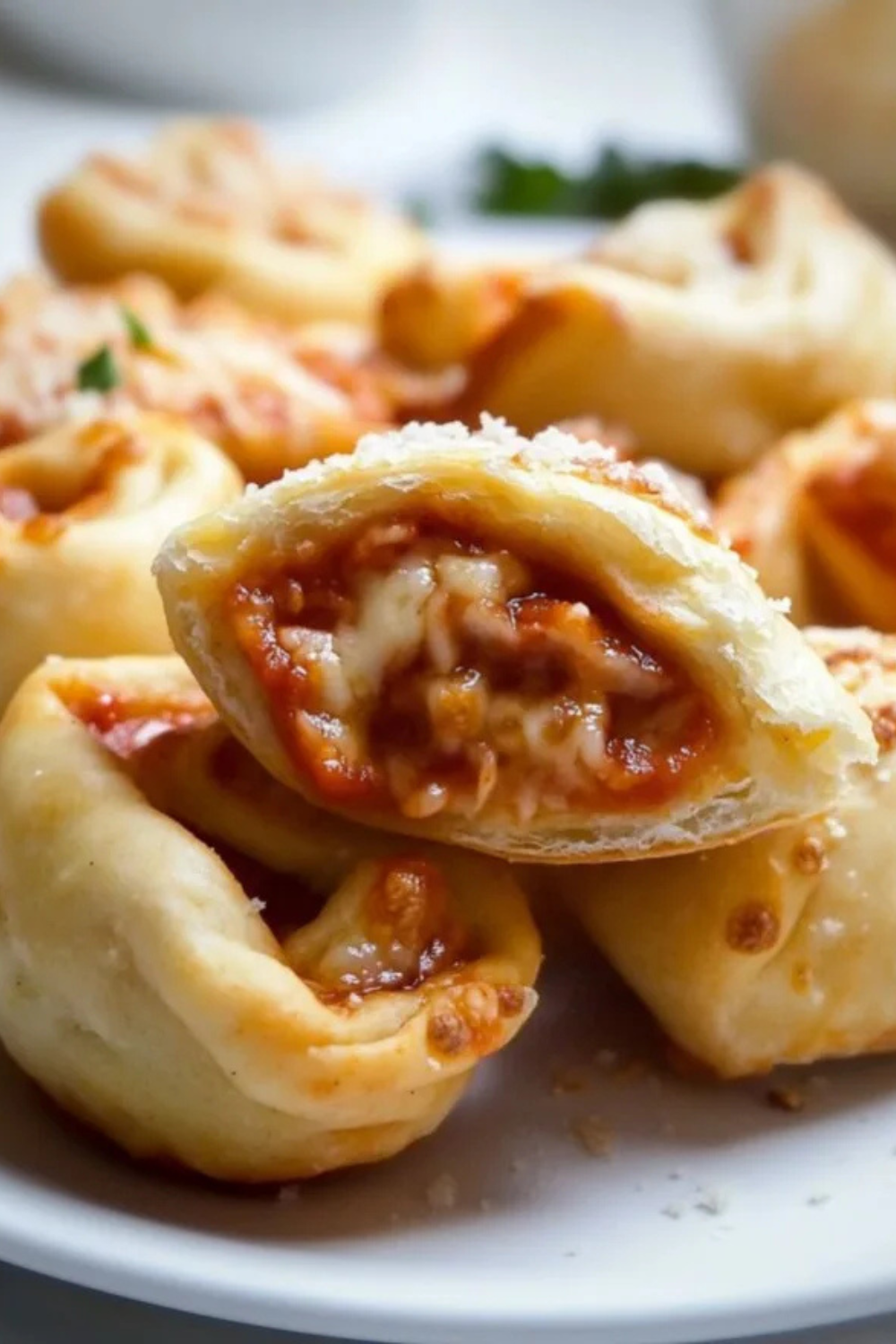 Easy homemade pizza rolls on a baking sheet golden brown and crispy served with marinara dipping sauce
