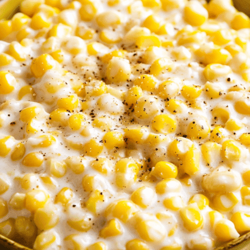 slow cooker creamed corn in a white serving bowl