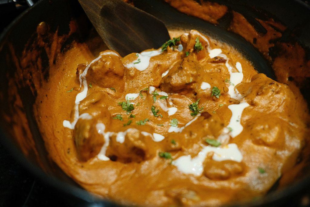 Easy slow cooker butter chicken in a rich creamy coconut curry sauce served over basmati rice with fresh cilantro