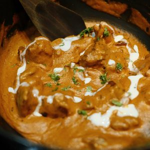 Easy slow cooker butter chicken in a rich creamy coconut curry sauce served over basmati rice with fresh cilantro