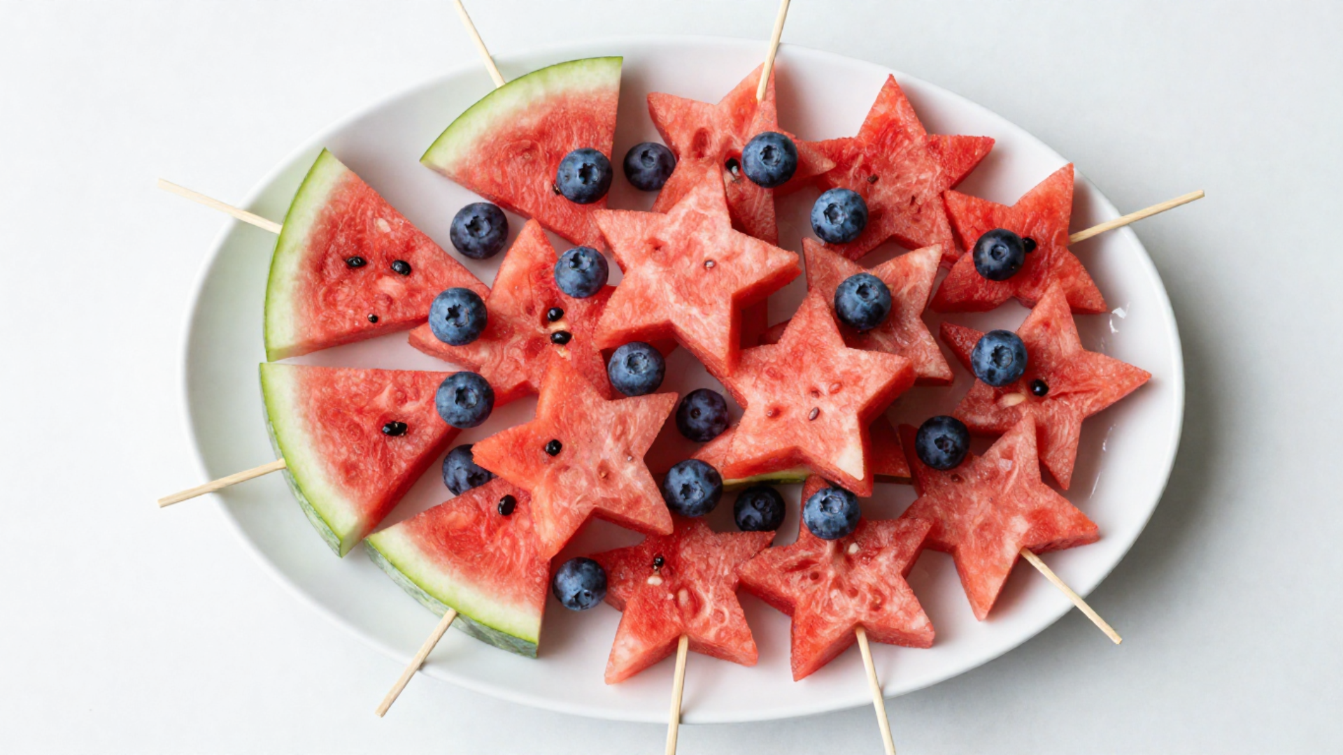 watermelon stars on skewers with blueberries served on a platter