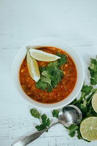 Bowl of crockpot chicken tortilla soup topped with crispy tortilla strips shredded cheese sour cream and avocado