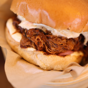Close-up of slow cooker apple cider pulled pork piled high on a soft bun